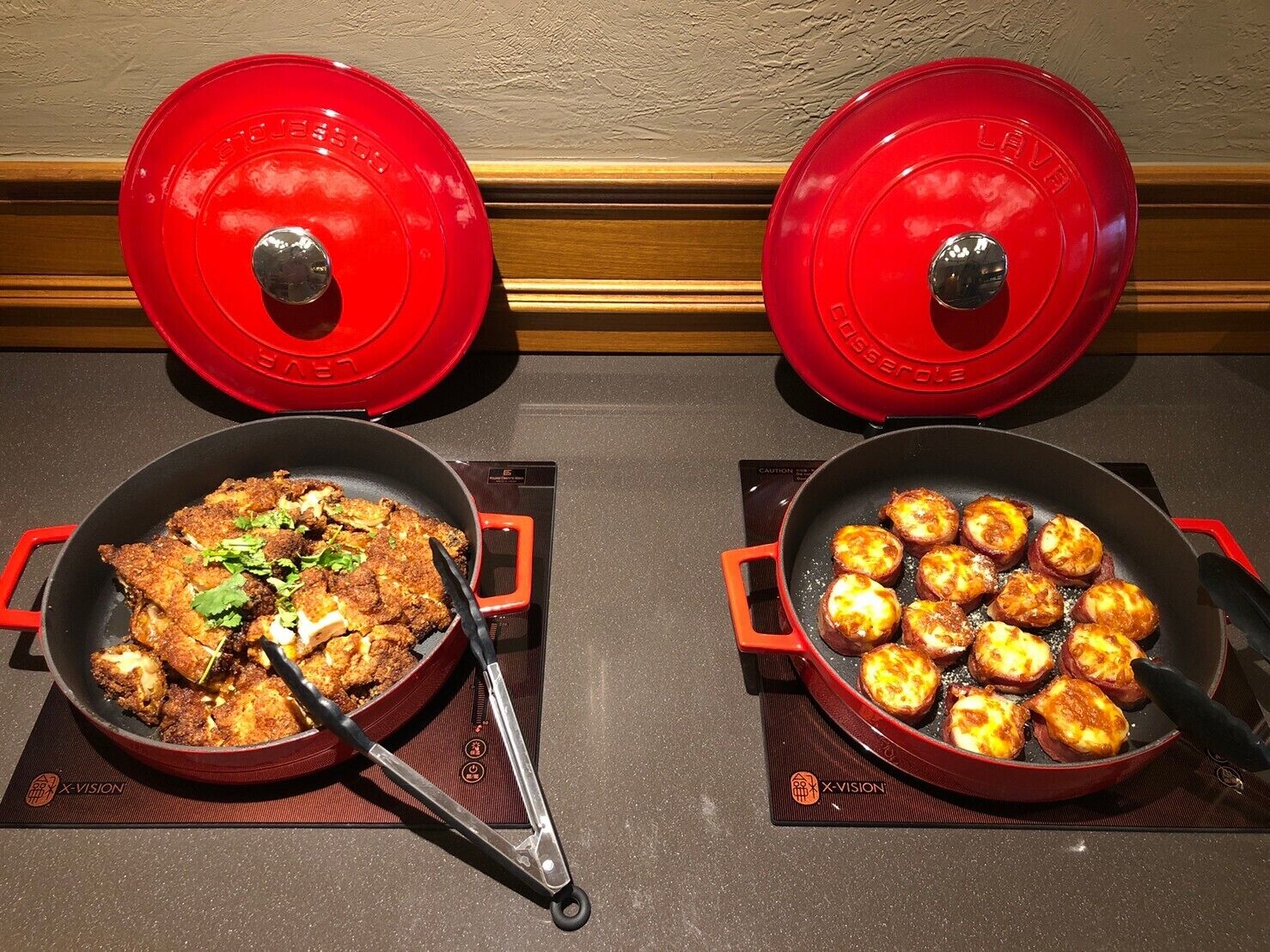 Deux casseroles rouges sur des plaques de cuisson à induction, contenant des aliments.