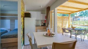 Alojamiento moderno y funcional con kitchenette, un comedor con mesa y sillas, y una zona de descanso con literas.