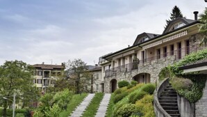 A multi-story building with a stone staircase leading up to a balcony. - Achillea by Interhome (Luino)