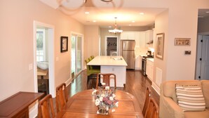 A modern kitchen with a central island, wooden dining table, and chairs. - Ranch, 6 bedrooms and 5 baths home near Parris Island and Beaufort is beautiful. (St Helena Island)