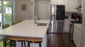 A modern kitchen with a central island, stainless steel appliances, and white cabinetry. - Ranch, 6 bedrooms and 5 baths home near Parris Island and Beaufort is beautiful. (St Helena Island)