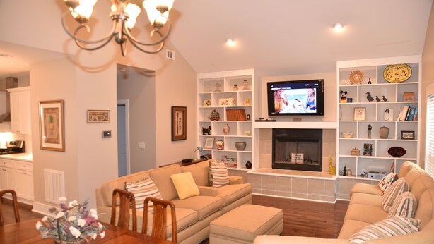 A living room with a fireplace, a television, and a dining area with a table and chairs. - Ranch, 6 bedrooms and 5 baths home near Parris Island and Beaufort is beautiful. (St Helena Island)
