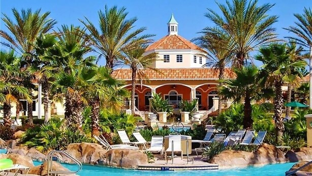 Un resort con piscina, palmeras y un edificio con techo abovedado.