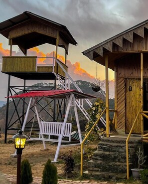 A two-story wooden building with a balcony and a staircase leading to the upper level. - BSR Farms (Pauri)