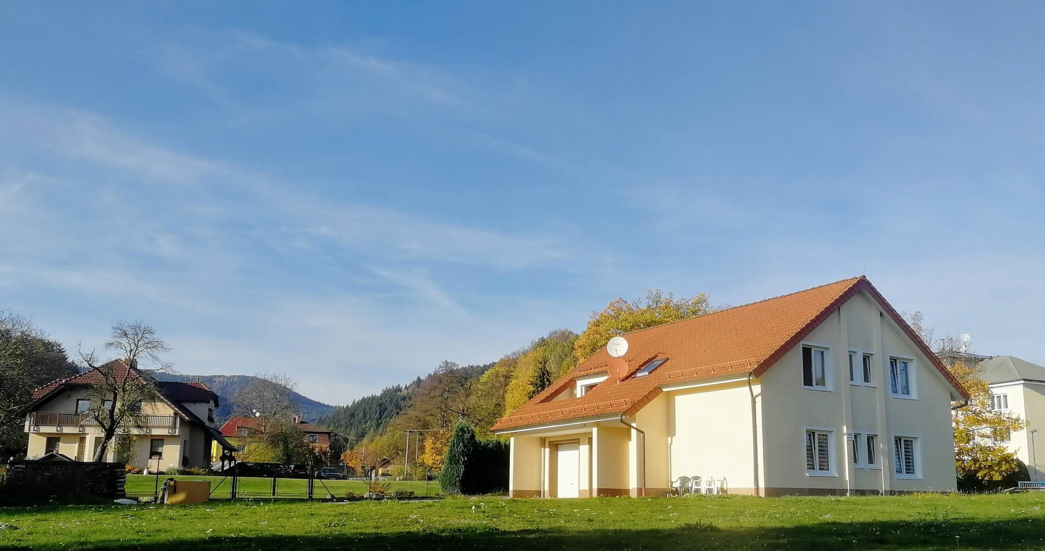 Ein Wohngebiet mit Häusern, blauem Himmel und einem grünen Rasen.