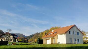 Ein Wohngebiet mit Häusern, blauem Himmel und einem grünen Rasen.