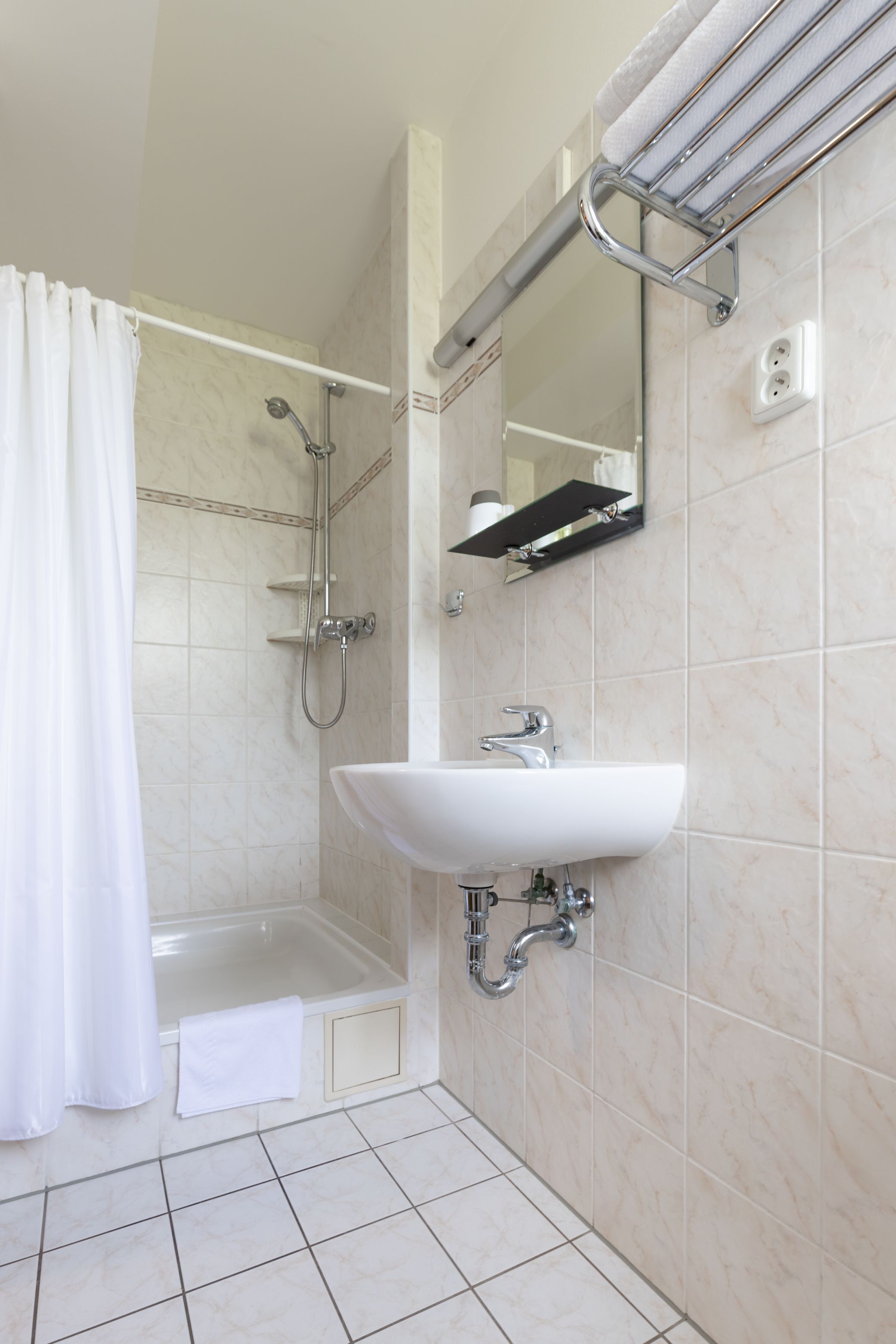 Un baño con bañera, ducha y lavamanos.