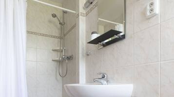 Un baño con bañera, ducha y lavamanos.