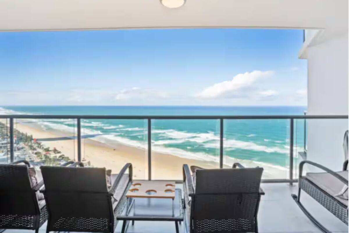 A balcony with a view of the beach and ocean.