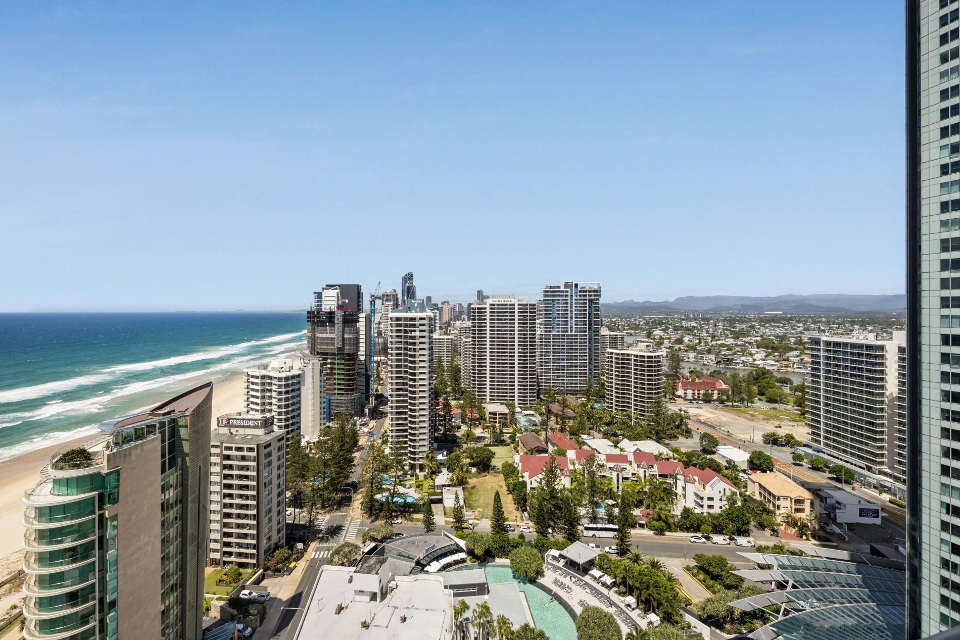 Ein Hochhotel mit Blick auf einen Strand, das Meer und die Stadtlandschaft.