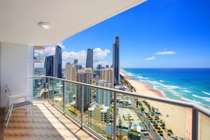 Un balcón con vista a la playa y al paisaje urbano.