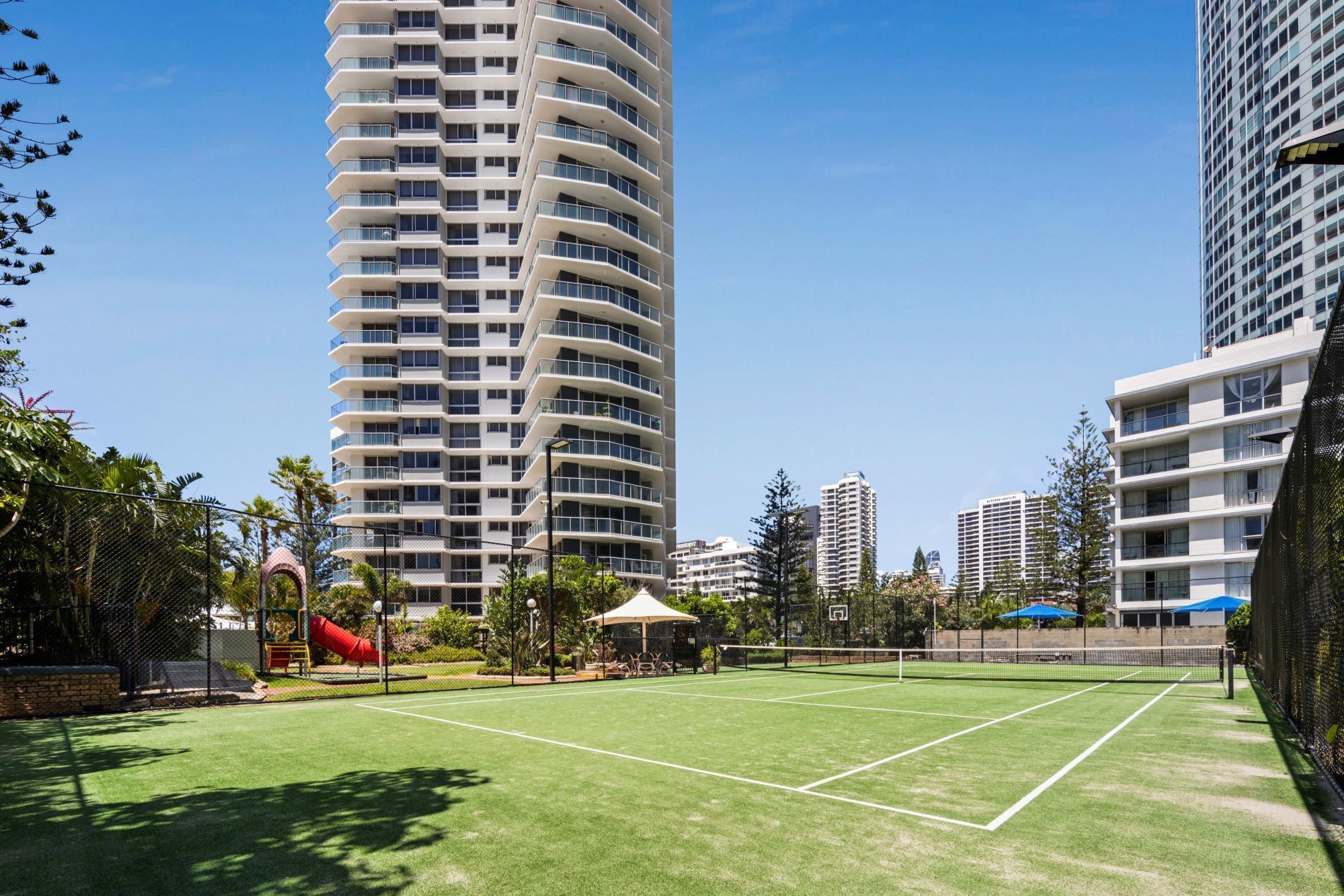 A sports court surrounded by tall residential buildings.
