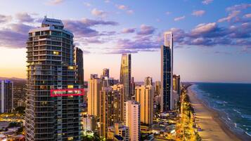 Un paisaje urbano costero con edificios altos, una playa y cielo despejado.