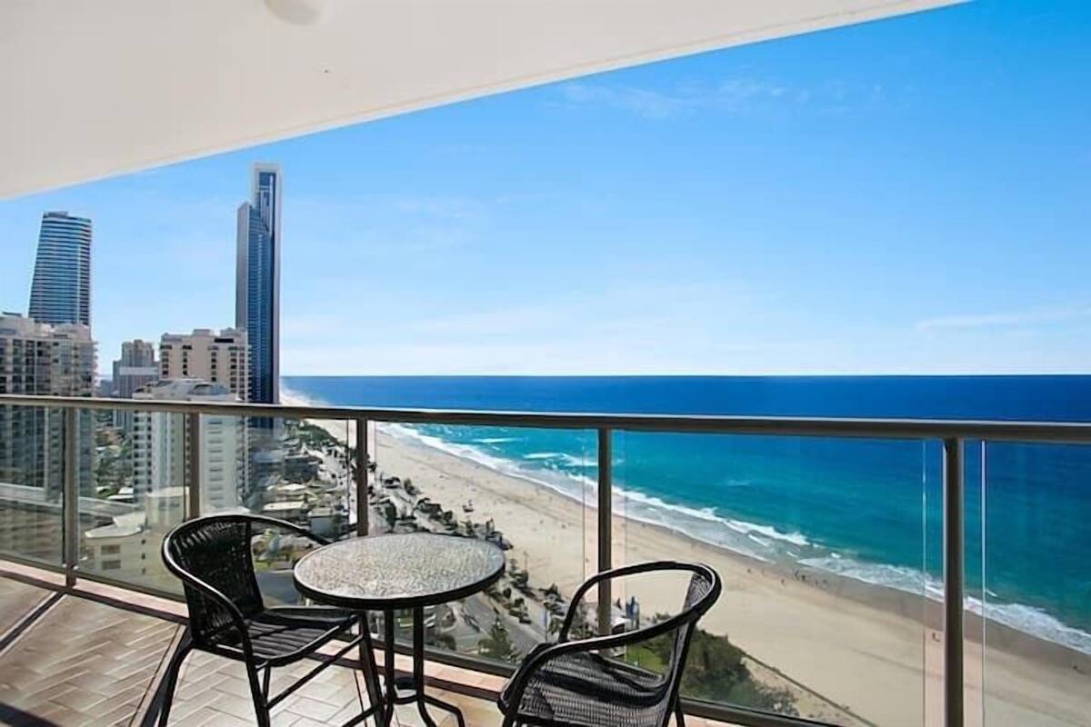 A balcony with a view of the beach and city skyline.