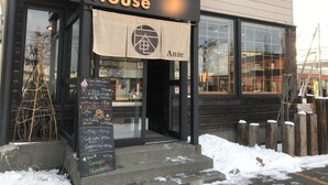 A building with a sign reading "Guest House" and a signboard with various items listed. - Sapporo Guest House Anne - Hostel (Sapporo)