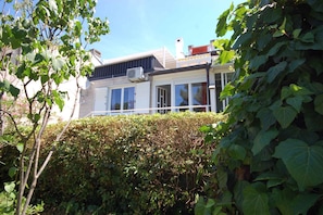 Een modern huis met grote ramen, een balkon en een witte gevel.