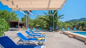 A poolside area with lounge chairs and a pergola.