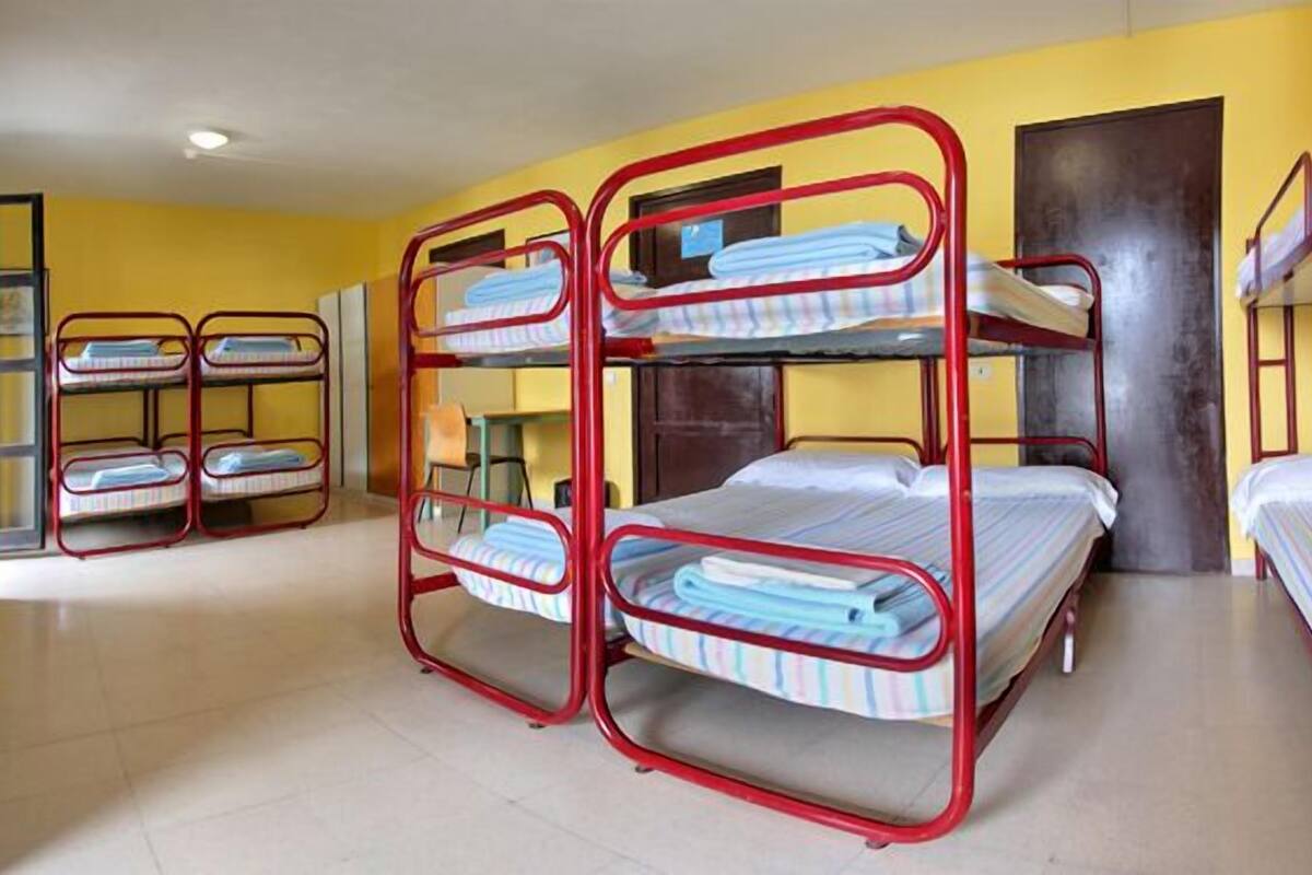 A dormitory room with bunk beds and a door.
