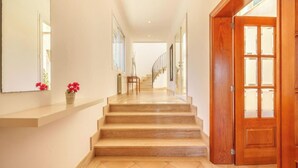 Eine Treppe führt zu einer zweiten Etage, rechts befindet sich eine Holztür.