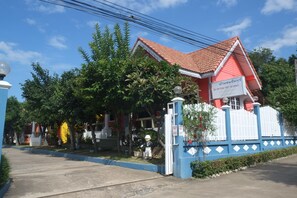 A red-roofed building with a blue and white fence, surrounded by greenery. - Baan Chom Chan Resort (Sattahip)