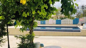 Un espace extérieur aménagé avec des sièges et une piscine en arrière-plan.