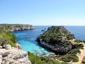 Un paysage côtier caractérisé par un terrain rocheux et des eaux d’un bleu limpide.