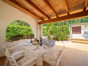 Enjoy al fresco dining in a serene setting surrounded by lush greenery and a charming view.