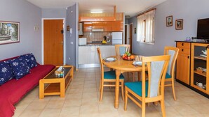 Un espace de vie compact comprenant un coin repas, une kitchenette et un canapé.