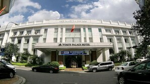 The exterior of the White Palace Thai Binh hotel with a prominent entrance and a flag.
