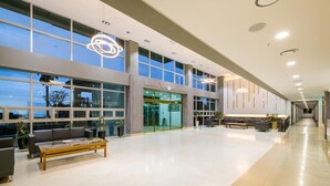 Un hall d’entrée spacieux, doté d’un haut plafond, de grandes fenêtres et d’un éclairage moderne.