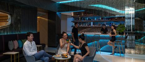 Zona de bar moderna con asientos y una barra.