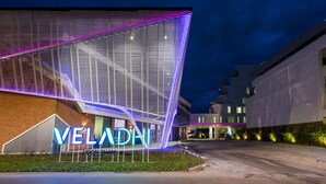 Moderni rakennus, jonka julkisivussa on suuri, valaistu kyltti, jossa lukee: ”VELADHI UPTOWN”.