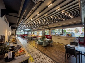 A modern restaurant with a long counter, various food stations, and seating areas. - Leaf Port Hotel (Konyaalti)