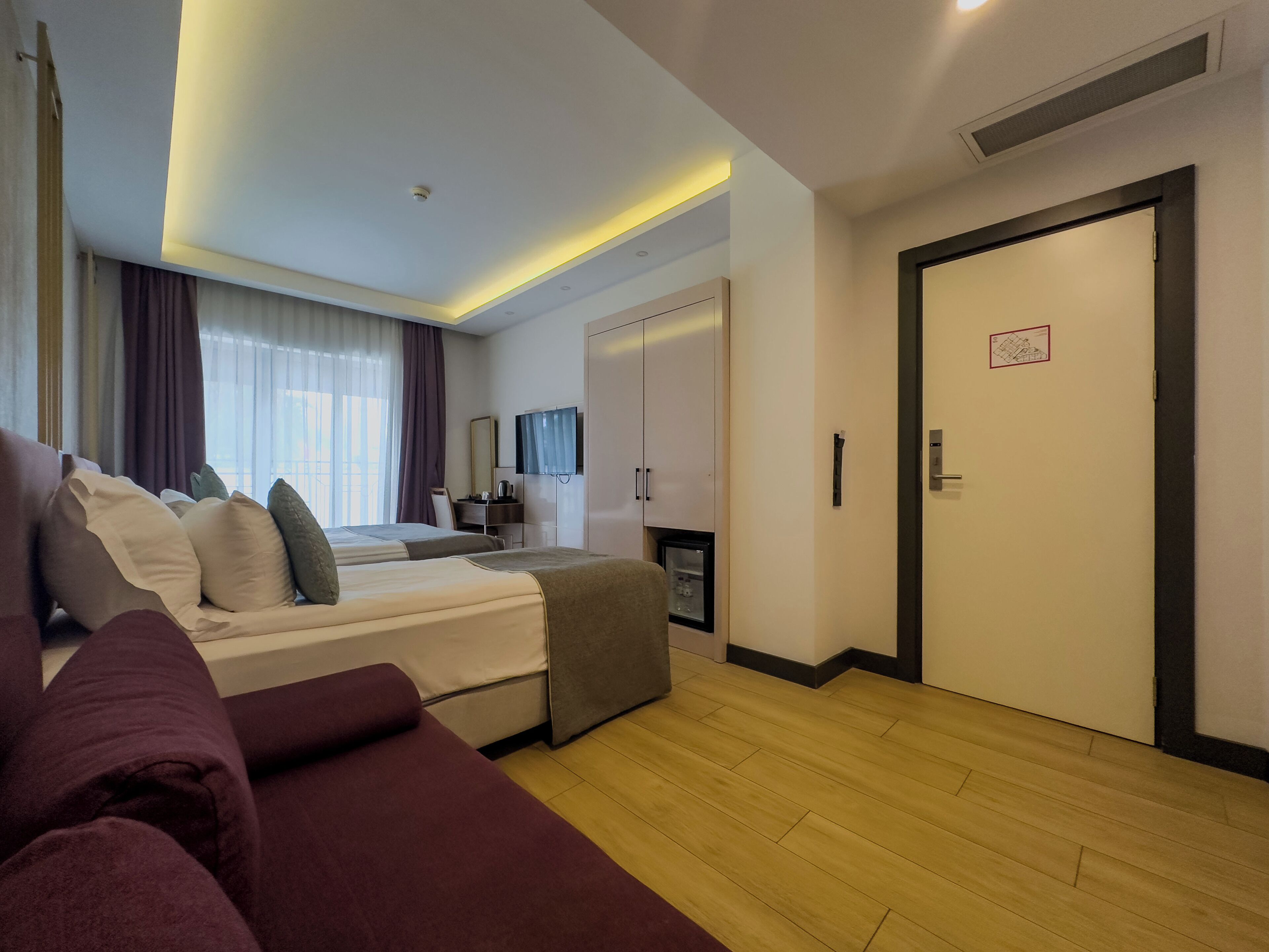 Una habitación de hotel moderna con una cama grande, un sofá, un escritorio y una televisión.