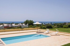 A swimming pool with two lounge chairs and a view of the ocean. - Marsa Siclà Le Ville (Scicli)