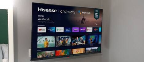 Un televisor Hisense en la pared mostrando una interfaz temática de Westworld con varias aplicaciones de transmisión.