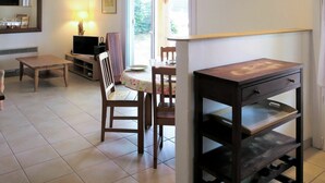 Un coin repas avec une table et des chaises, un téléviseur et une lampe.
