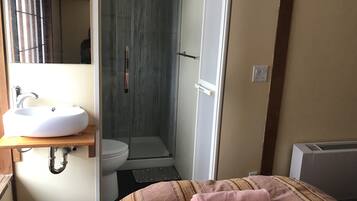 A bathroom with a sink, toilet, and shower.