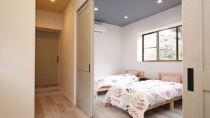 A bedroom with two beds, a sliding door, and a window. - Kanau (Gojo)