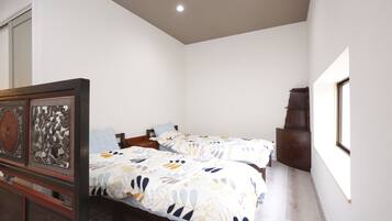 A bedroom with two beds, a wooden headboard, and a cabinet.