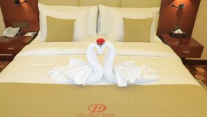 A hotel room with a neatly made bed, a rose on the pillows, and a swan towel design. - Desalegn Hotels Lodge And Apartment (Addis Ababa)
