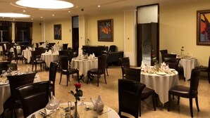 A dining area with round tables, chairs, and a central column. - Desalegn Hotels Lodge And Apartment (Addis Ababa)