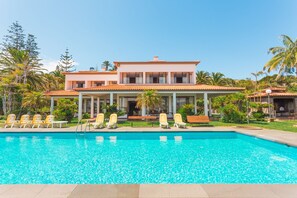 A modern hotel with a swimming pool, lounge chairs, and a covered patio area. - FLH Luxury Villa Mar with Private Sea Access (Funchal)