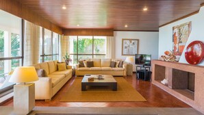 A spacious living room with a sofa set, a coffee table, and a TV. - FLH Luxury Villa Mar with Private Sea Access (Funchal)