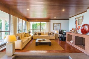 Una sala de estar amplia con un conjunto de sofá, una mesa de centro y un televisor.