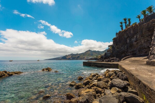 A coastal scene with clear blue water, rocky shore, and a concrete pathway along the cliff. - FLH Luxury Villa Mar with Private Sea Access (Funchal)