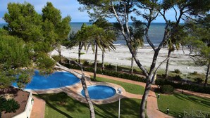 A pool surrounded by trees and a beach view. - Anacasa Penthouse Azul Marino Almadrava AT2202 (Denia)