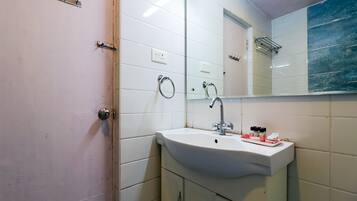 A bathroom with a white sink, a mirror, and a towel rack.