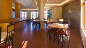 A spacious dining area with high ceilings, large windows, and a modern design.