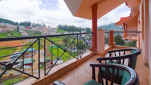 A balcony with a view of a residential area, including houses and greenery.